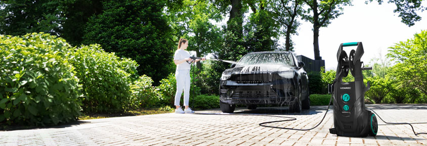 Frau reinigt Auto mit VONROC V25 Hochdruckreiniger